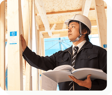 ヘルメットを被った男性が建設中の建物を確認している