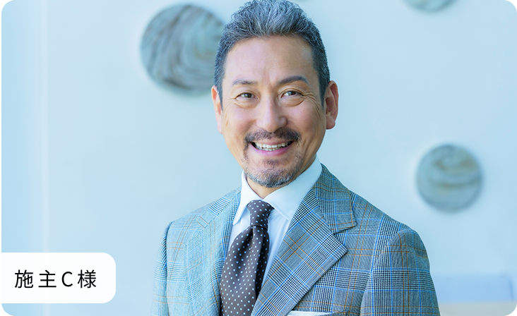 60代ほどの男性がこちらをみて微笑んでいる